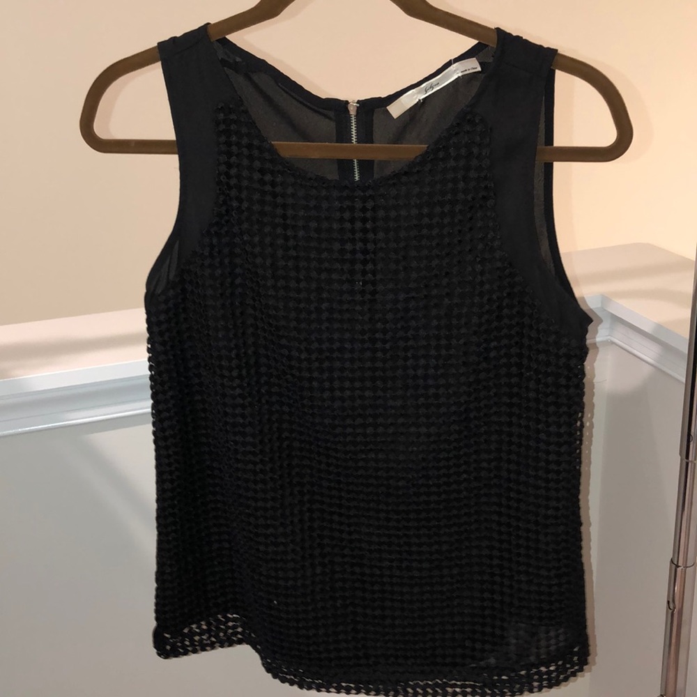 Sheer black top with circular texture detail.